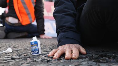 A protester from Insulate Britain with their hand glued to the road in Parliament Square, central London. Picture date: Thursday November 4, 2021.  